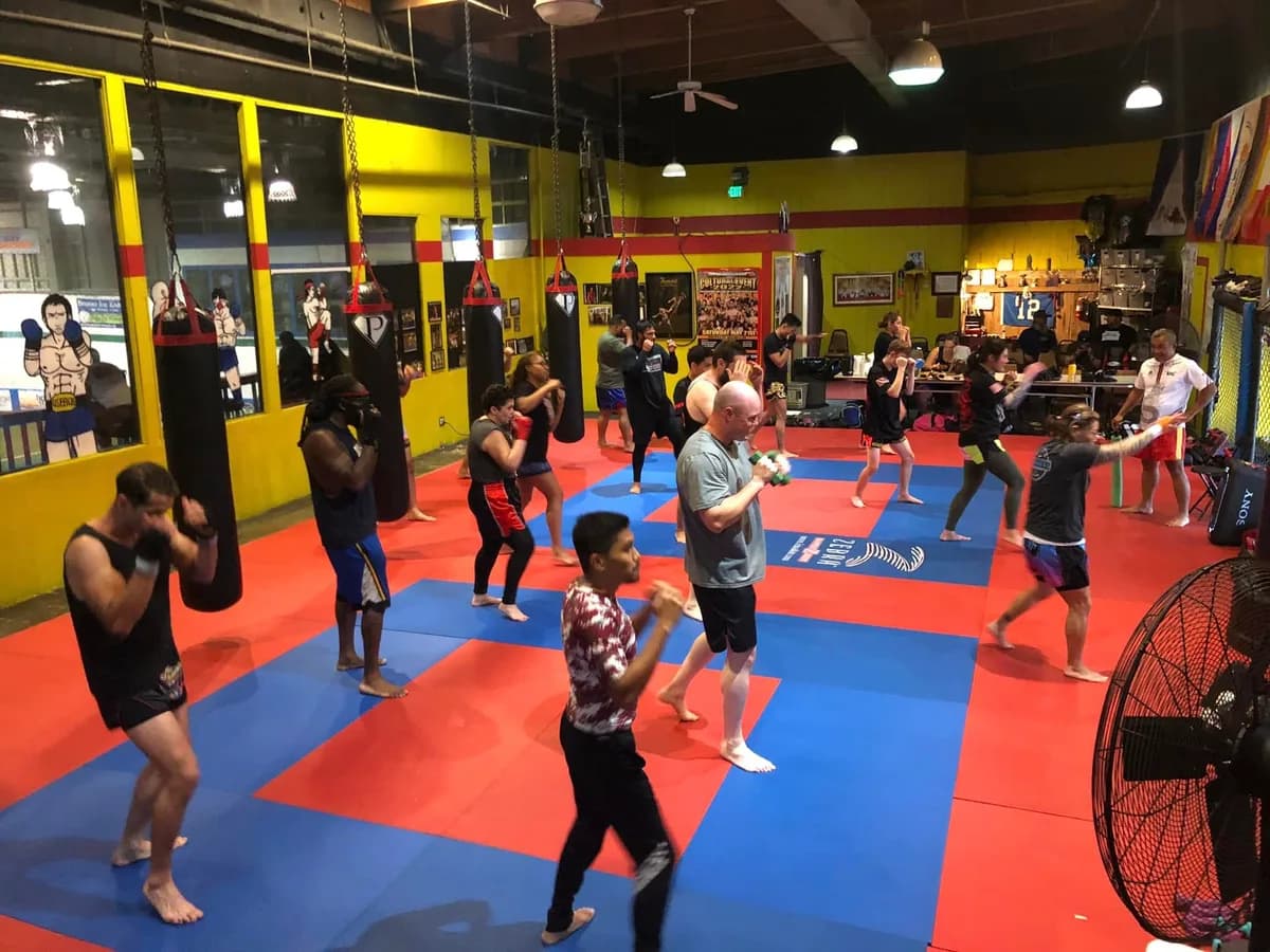 An adult Kun Khmer class working combinations across the mats at SSMA